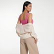 Model wearing modal henley bodysuit with cardigan, back angle